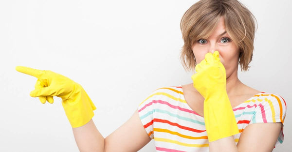 Woman plugging her nose to stop the smell of stink bugs
