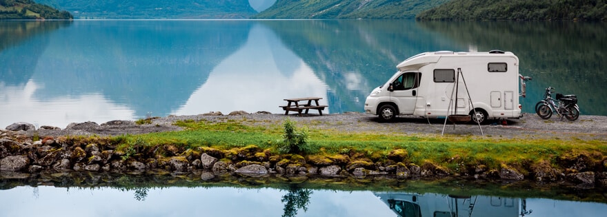 Camper van parked next to a mountain lake