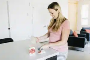 Woman placing a Stay Away pouch inside of her home